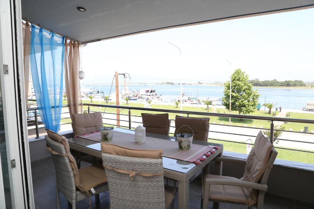 ケラモティにあるLakis Luxury Apartmentのテーブルと椅子、水辺の景色を望むバルコニー