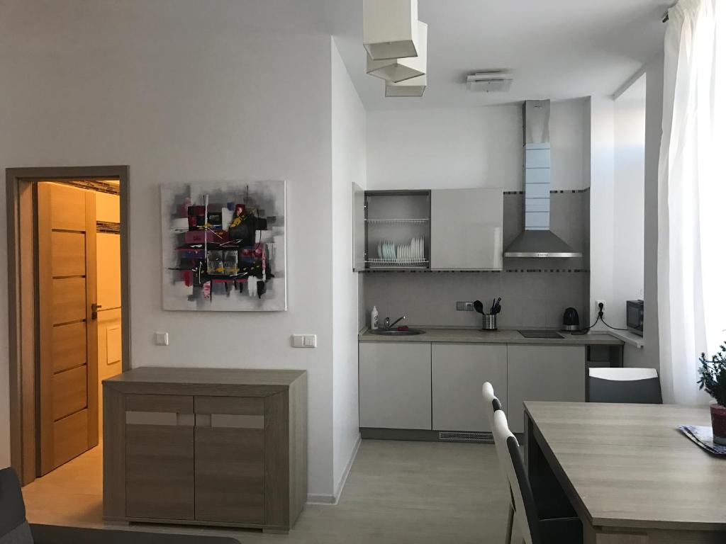 a kitchen with a table and a dining room at Taikos Apartmentai 2 in Druskininkai
