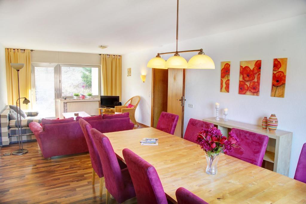 ein Esszimmer mit einem Tisch und lila Stühlen in der Unterkunft Haus Nova am Bollerberg in Hallenberg