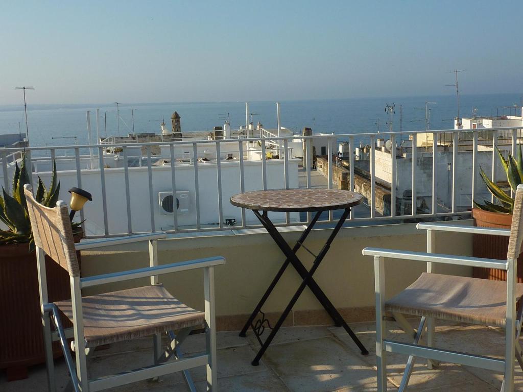 una mesa y sillas en un balcón con vistas al océano en Casa Nelly, en Gallipoli