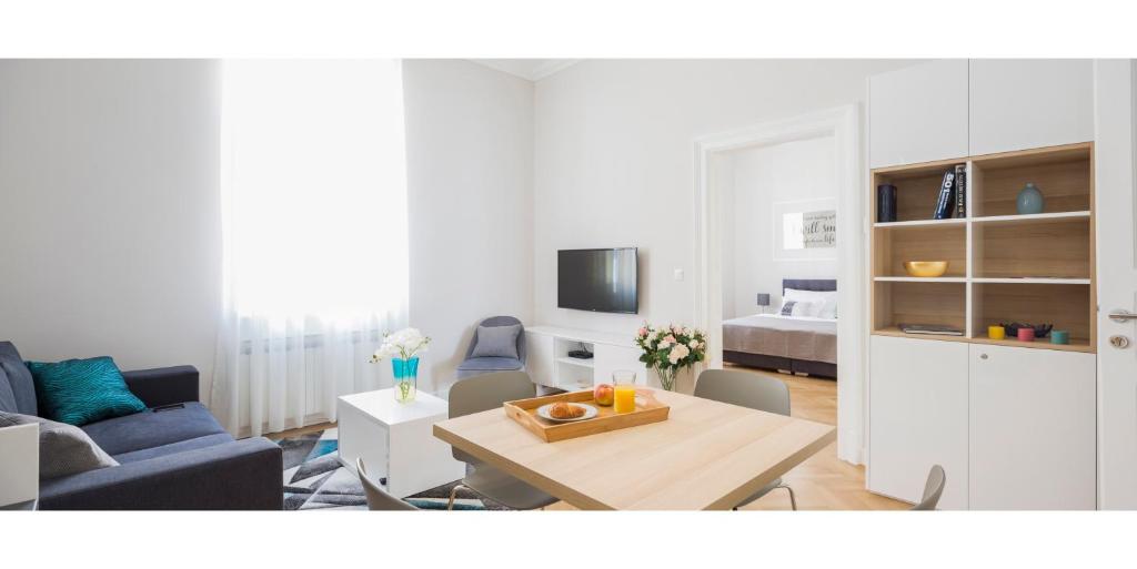 un soggiorno con tavolo e divano di White Rose Apartment a Zagabria