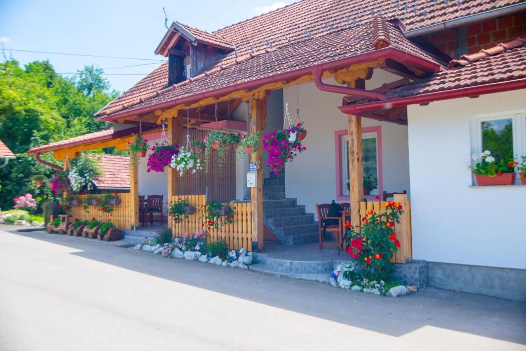 ein Haus mit Blumen auf der Vorderseite in der Unterkunft Guesthouse Ella in Slunj