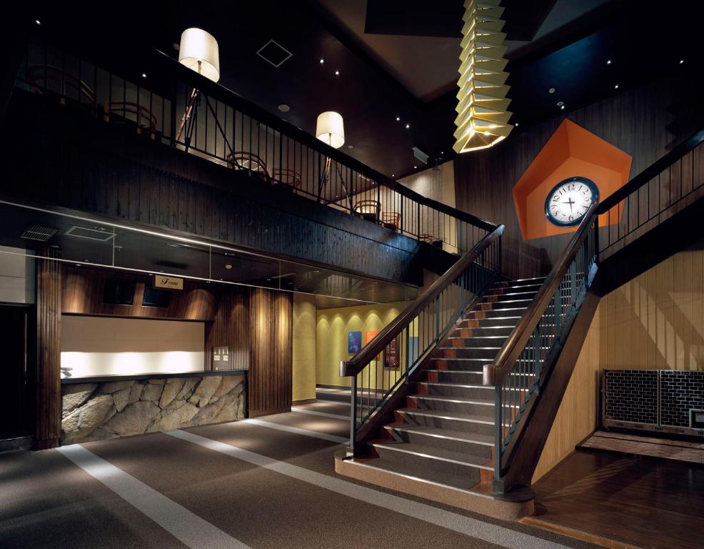 a staircase in a building with a clock on the wall at Kashimayari Sports Village in Omachi