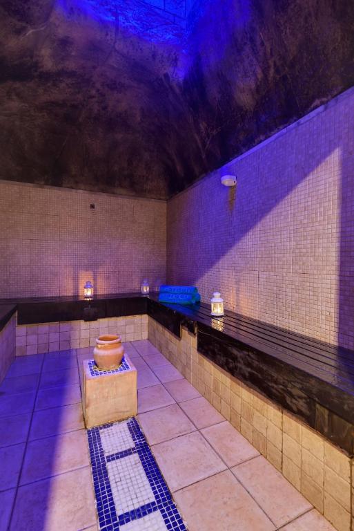 a large bathroom with a tile floor and purple lighting at Garden Playanatural - Adults Only in El Rompido
