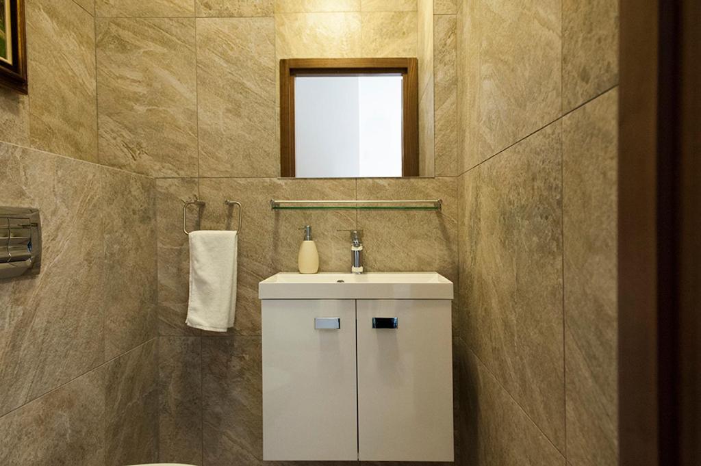 a bathroom with a sink and a mirror at DOMOTEL MOKOTÓW in Warsaw