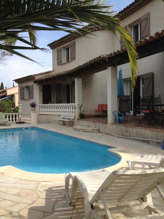 uma piscina com duas cadeiras e uma casa em Lac Saint Esprit em Fréjus