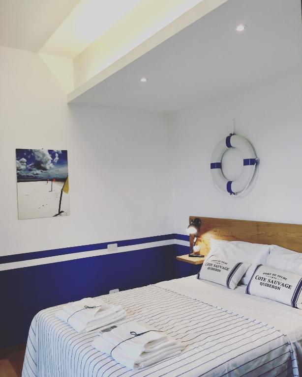 a bedroom with a bed with a blue and white blanket at La Goiaba B&B in Senigallia