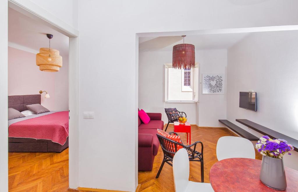 uma sala de estar com uma cama, uma mesa e cadeiras em Apartment Dox em Dubrovnik