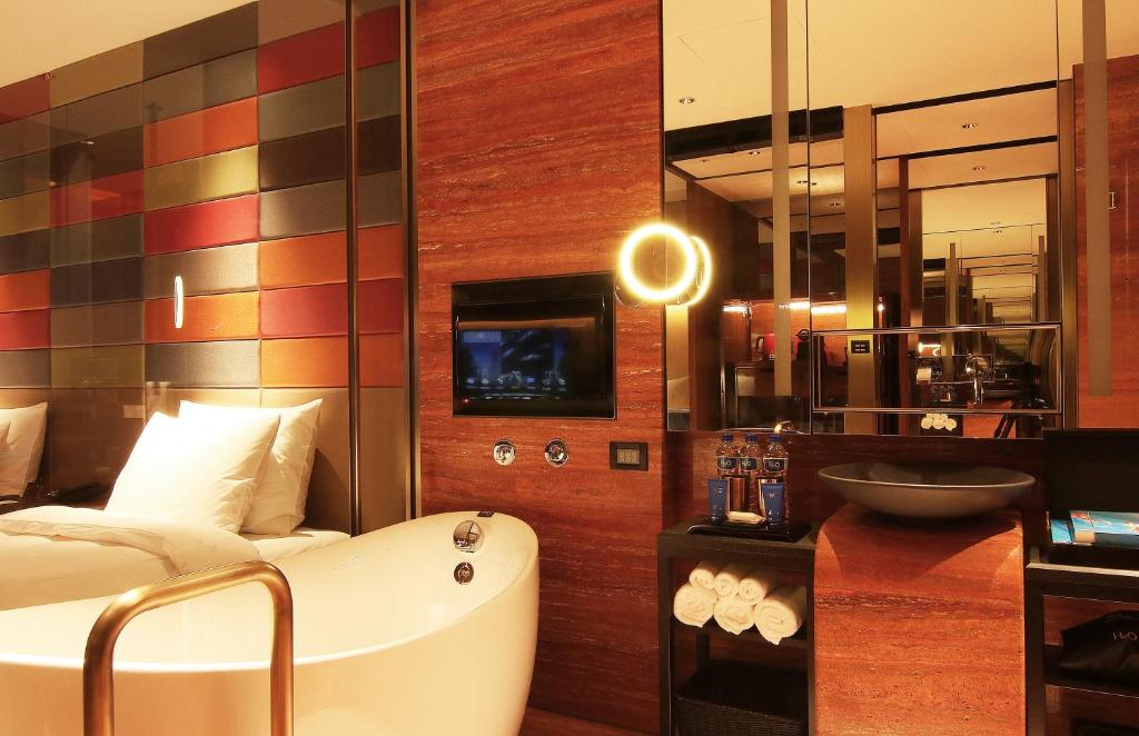 a hotel room with a bath tub and a bed at H2O HOTEL in Kaohsiung