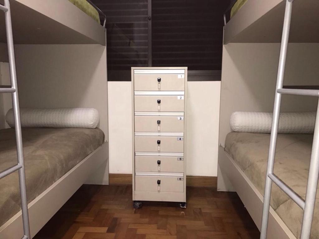 1 Schlafzimmer mit 2 Etagenbetten und einer Kommode in der Unterkunft Hostel Flor de Maria in São Paulo