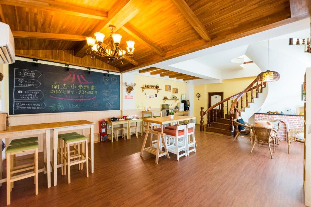 een restaurant met tafels en stoelen en een schoolbord aan de muur bij Tainan Minuet in Tainan