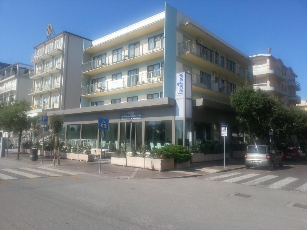 a large building with a car parked in front of it at Alba Appartamenti in Sottomarina