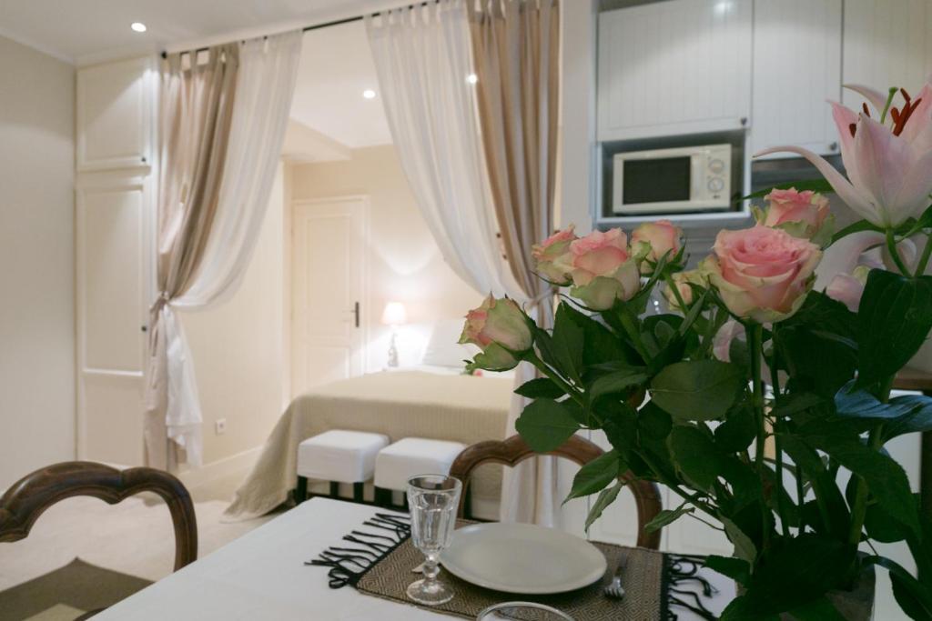 パリにあるQuartier Latin! 3 best Apartments in Paris With air conditioningのピンクのバラの花瓶とテーブル付きの部屋