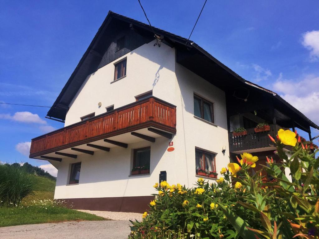 une maison blanche avec un toit noir dans l'établissement Homestay J&M, à Bled