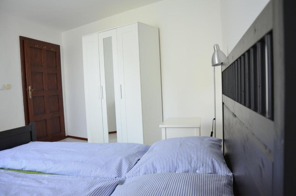 a bedroom with a bed and a wooden door at Apartmán Srdce Vltavy in Horní Planá