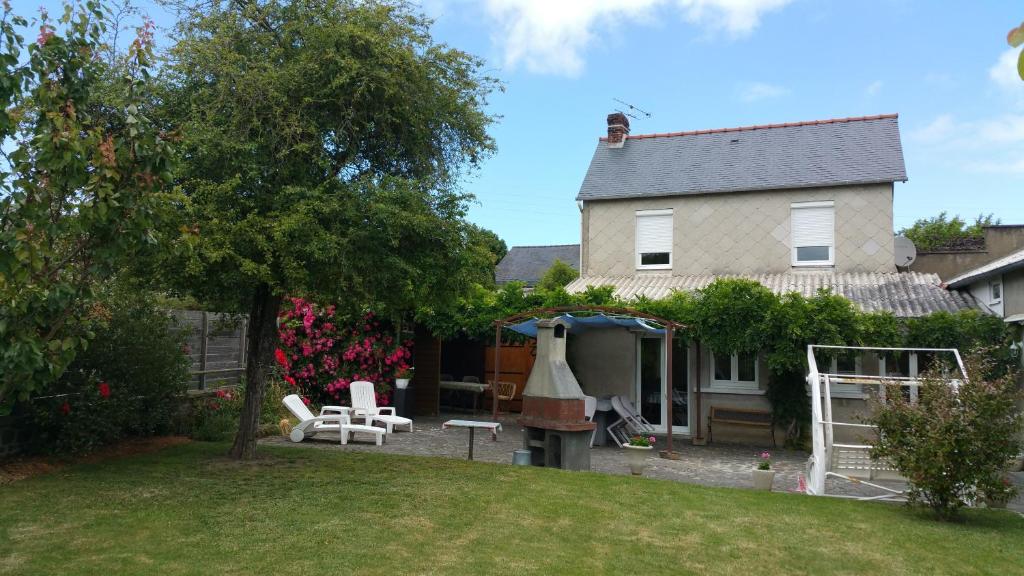 a house with a yard with chairs and a grill at Gîtes sains Baie du mont saint Michel LES HORTENSIAS in Sains