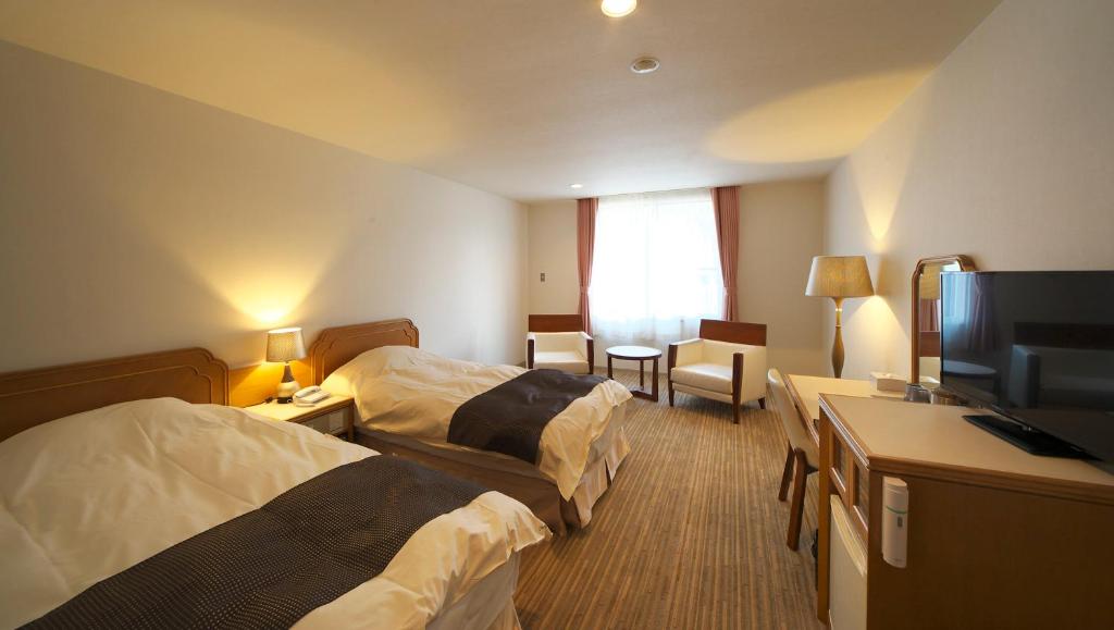 Postel nebo postele na pokoji v ubytování Motosu Phoenix Hotel
