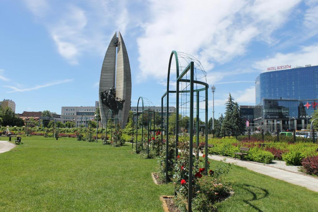 un jardín con flores y un edificio de fondo en Apartament Raz Dwa Trzy, en Rzeszów