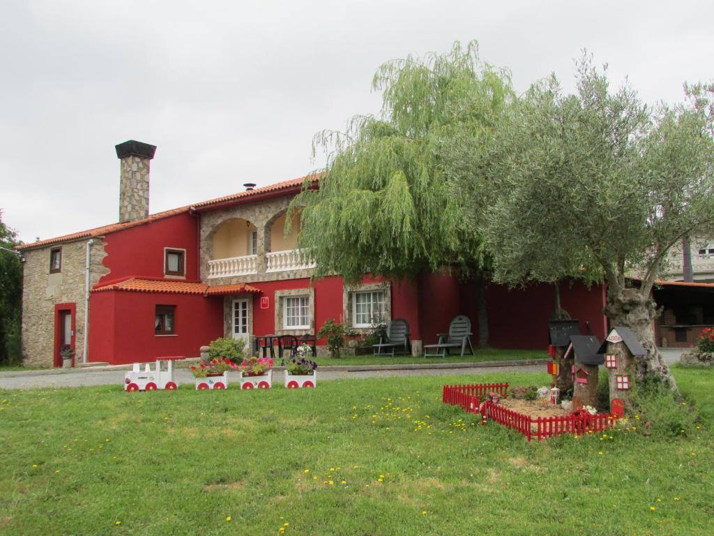 una casa roja con un árbol en el patio en Casa de Millares, en Porta