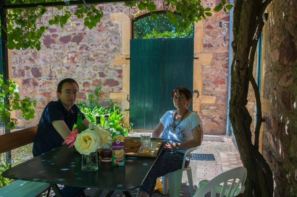 Hospitalite et patrimoine في Lentilly: رجل وامرأة يجلسون على طاولة