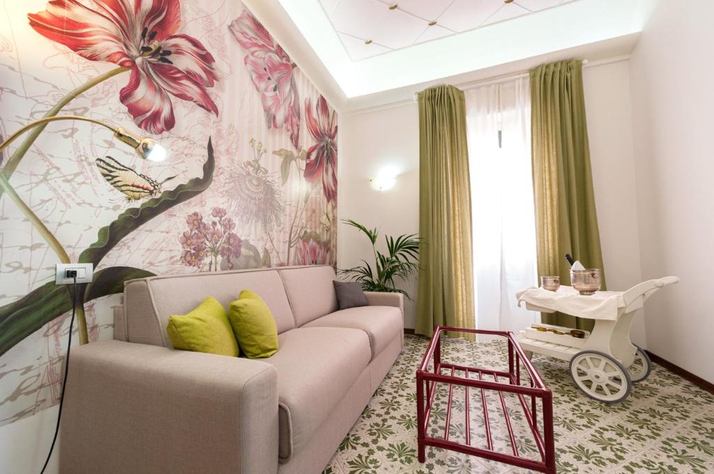 ein Wohnzimmer mit einem Sofa und einer Blumenwand in der Unterkunft Bed & Breakfast Antonello in Salerno