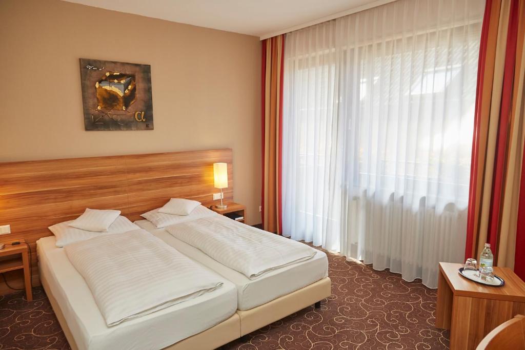 Postel nebo postele na pokoji v ubytování Flair Hotel Weinstube Lochner