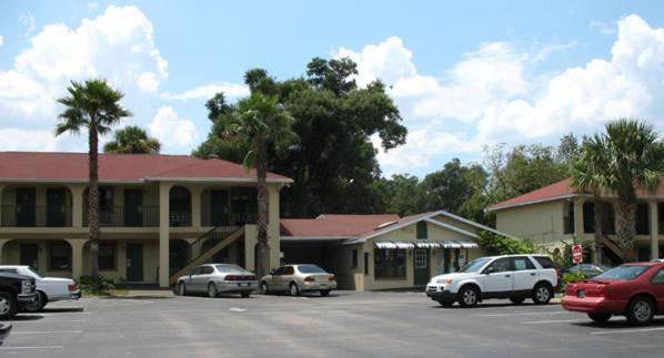 a parking lot with cars parked in front of a building at Orange City Motel - Orange City in Orange City