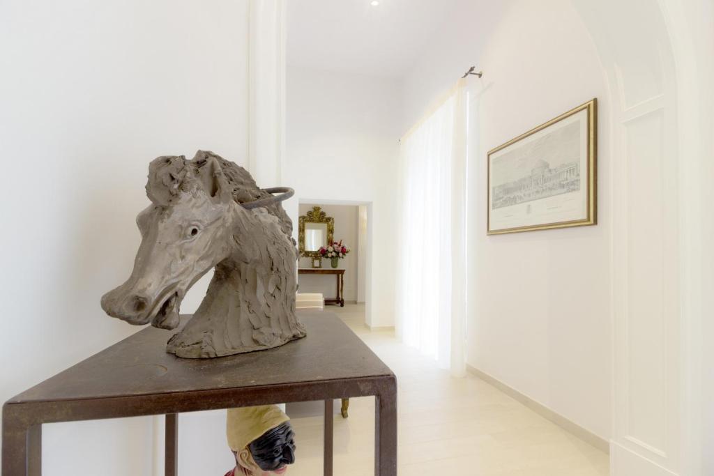 ナポリにあるPalazzo d'Auria ApartHotelの廊下のテーブル上の馬の彫刻