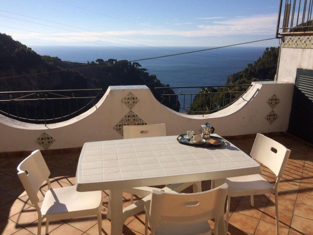 d'une table et de chaises sur un balcon avec vue sur l'océan. dans l'établissement Amalfi wonderful House, à Scala