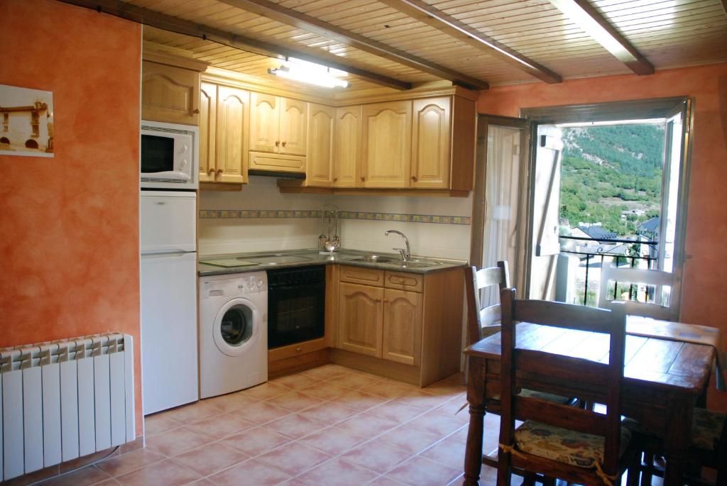 a kitchen with a washer and dryer and a table at Apartamento el Patio Casa Cajal in Torla