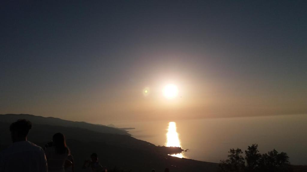 eine Gruppe von Menschen, die den Sonnenaufgang über dem Wasser beobachten in der Unterkunft Arte Mare e Cultura in Pettineo