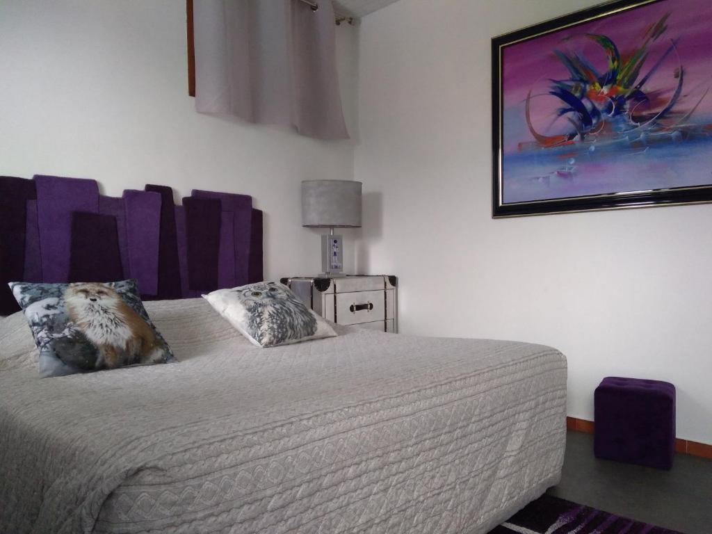 a bedroom with a bed and a painting on the wall at Charmant Horizon in La Turbie