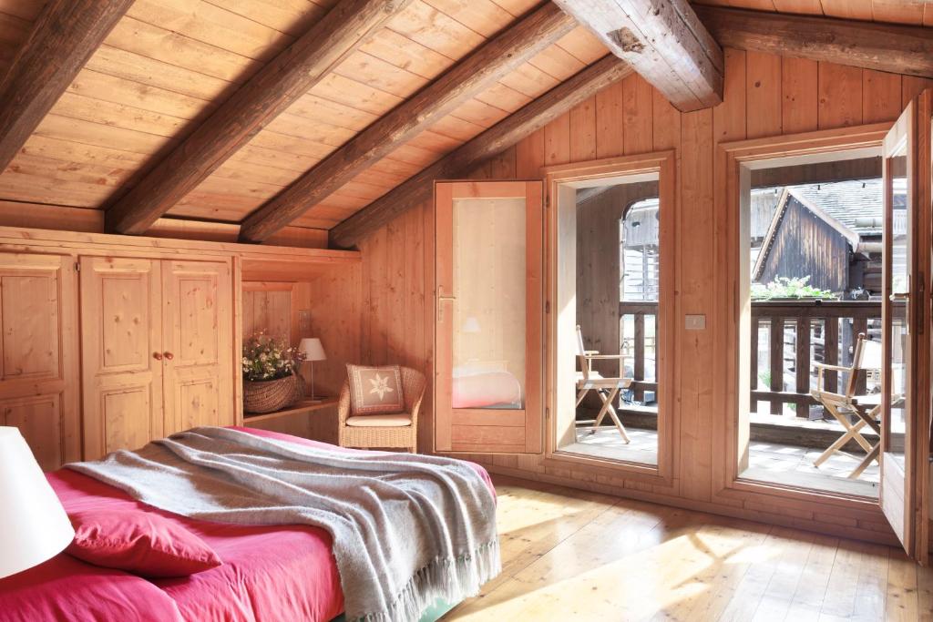 1 dormitorio con 1 cama en una habitación con paredes de madera en Albergo Diffuso Sauris in Sauris Di Sopra, en Sauris