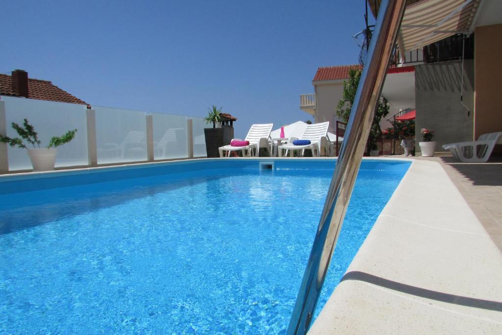 basen z niebieską wodą w budynku w obiekcie Apartments Bartulić w Trogirze