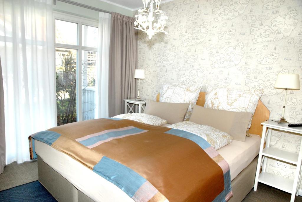 ein Schlafzimmer mit einem großen Bett und einem Kronleuchter in der Unterkunft Villa Luisa in Timmendorfer Strand