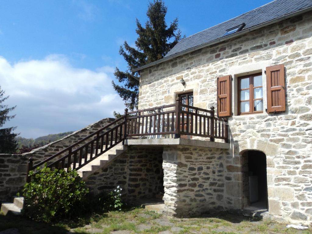 - un bâtiment en pierre avec un escalier et une fenêtre dans l'établissement Gite COMBRET, à Saint-Germain-du-Teil