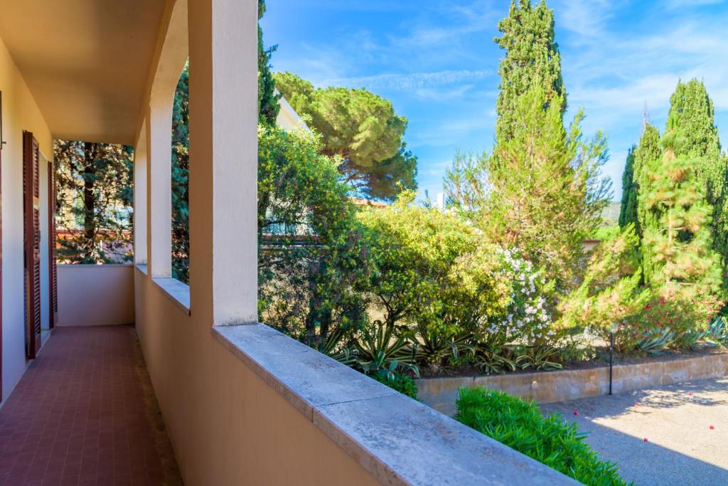 a balcony of a house with trees in the background at Appartamento Arancio in Procchio