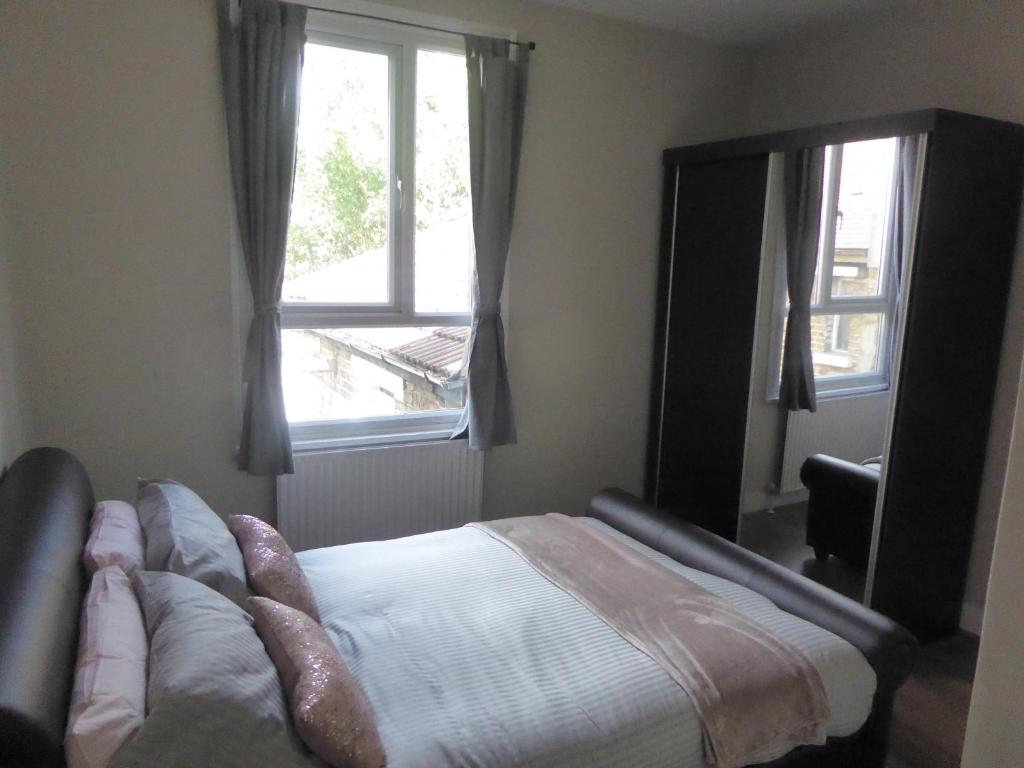 a bedroom with a bed and a large window at Turnpike House in London