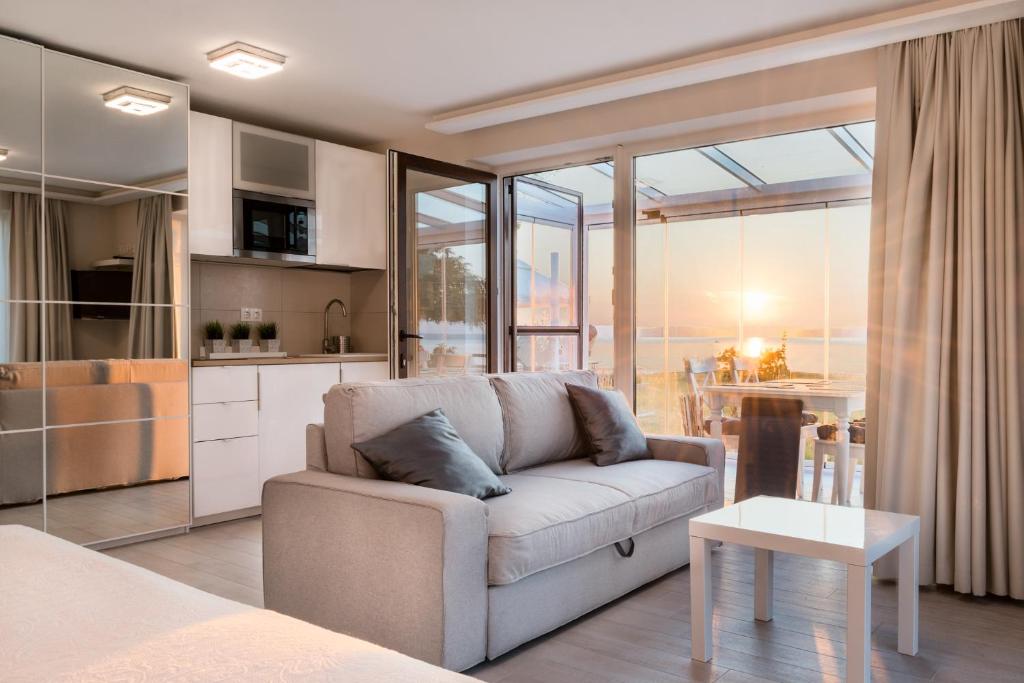 a living room with a couch and a kitchen at MobyDick Luxury Beach Apartment in Siófok
