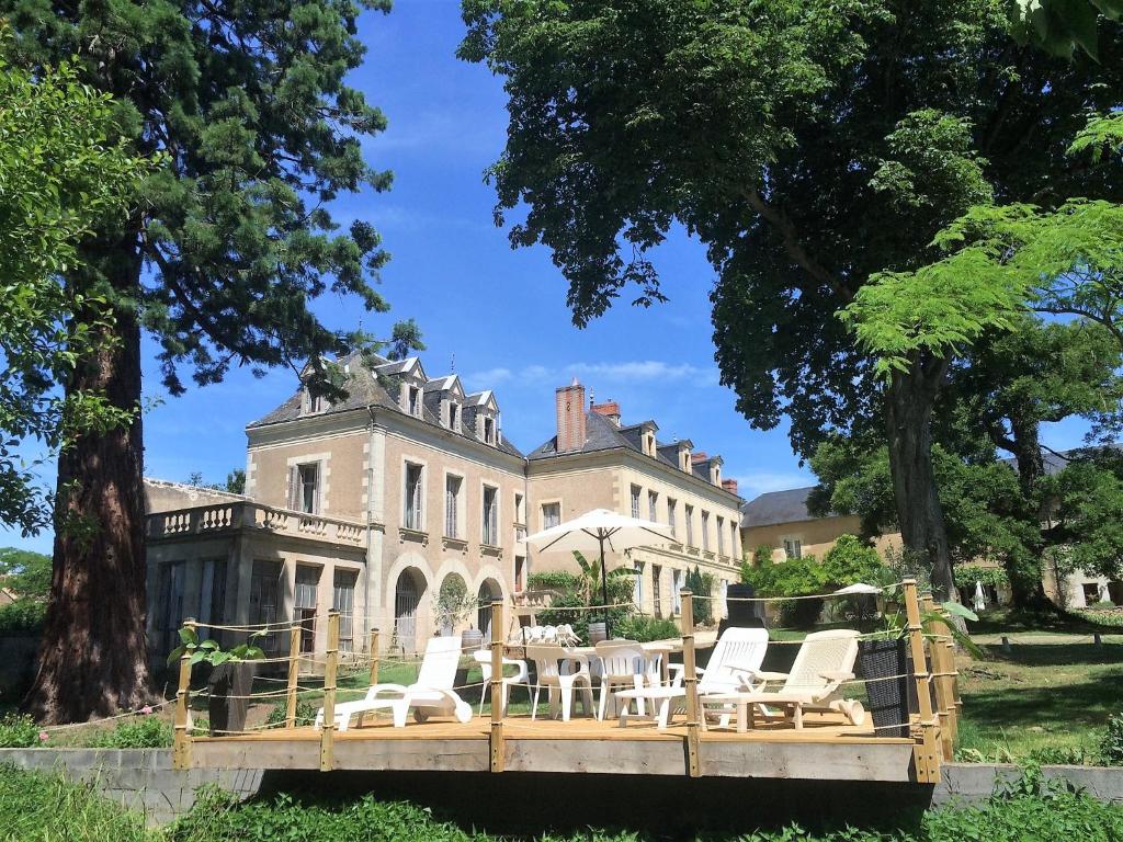 une maison avec des chaises et une table devant elle dans l'établissement La Grande Maison, à Pas-de-Jeu