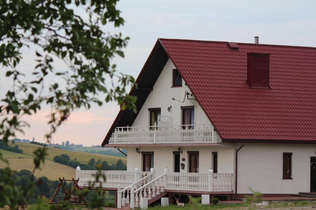 ein weißes Haus mit rotem Dach in der Unterkunft Grand Panorama in Wiśniowa