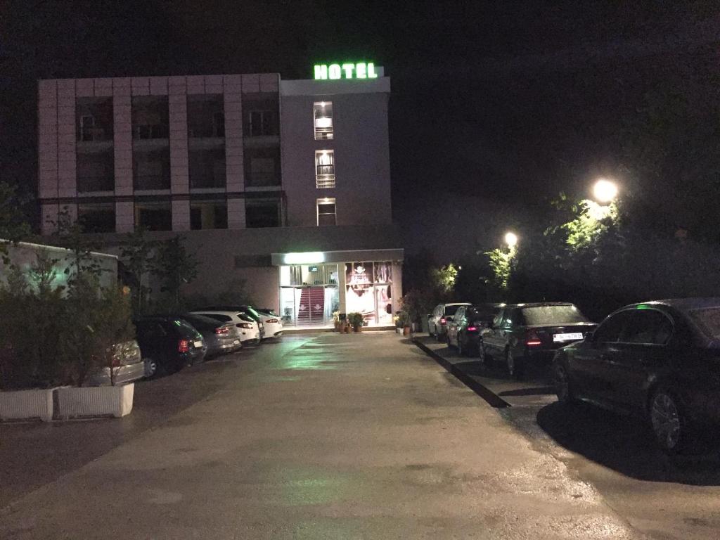 um parque de estacionamento em frente a um edifício à noite em Herges Hotel em Durrës