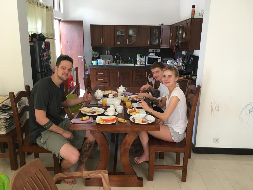 a group of people sitting around a table eating food at Pick & Go White House in Negombo