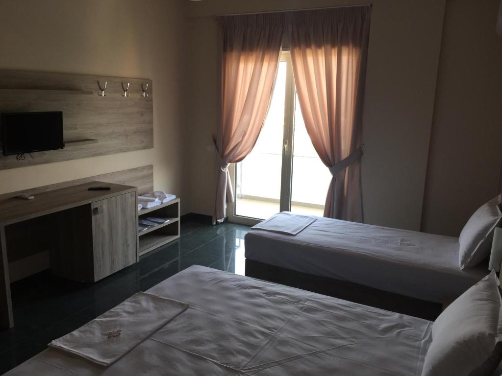 um quarto de hotel com duas camas e uma janela em Herges Hotel em Durrës