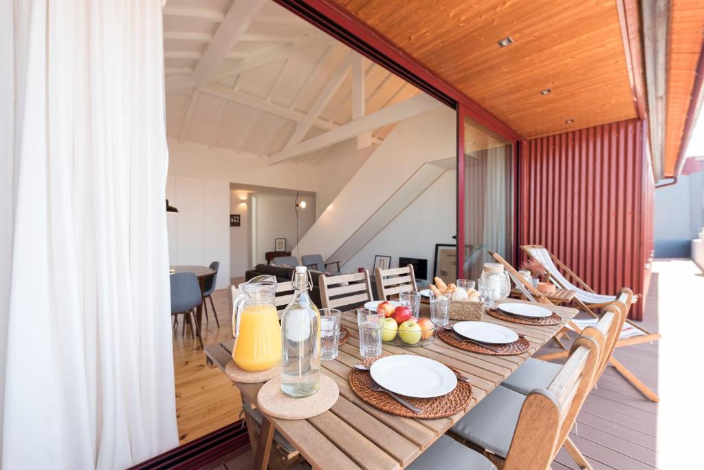 uma sala de jantar com uma mesa de madeira e cadeiras em LovelyStay - Top Floor Balcony Apartment no Porto