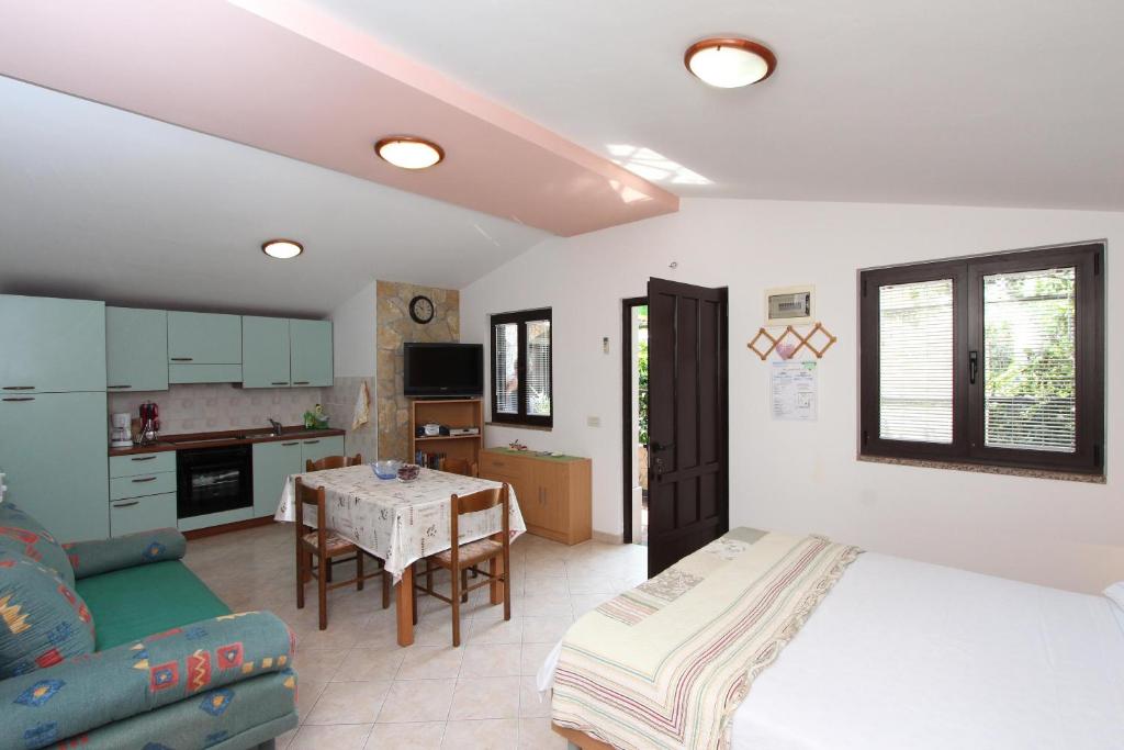 sypialnia z łóżkiem i stołem oraz kuchnią w obiekcie Apartments Marlina w Rovinj