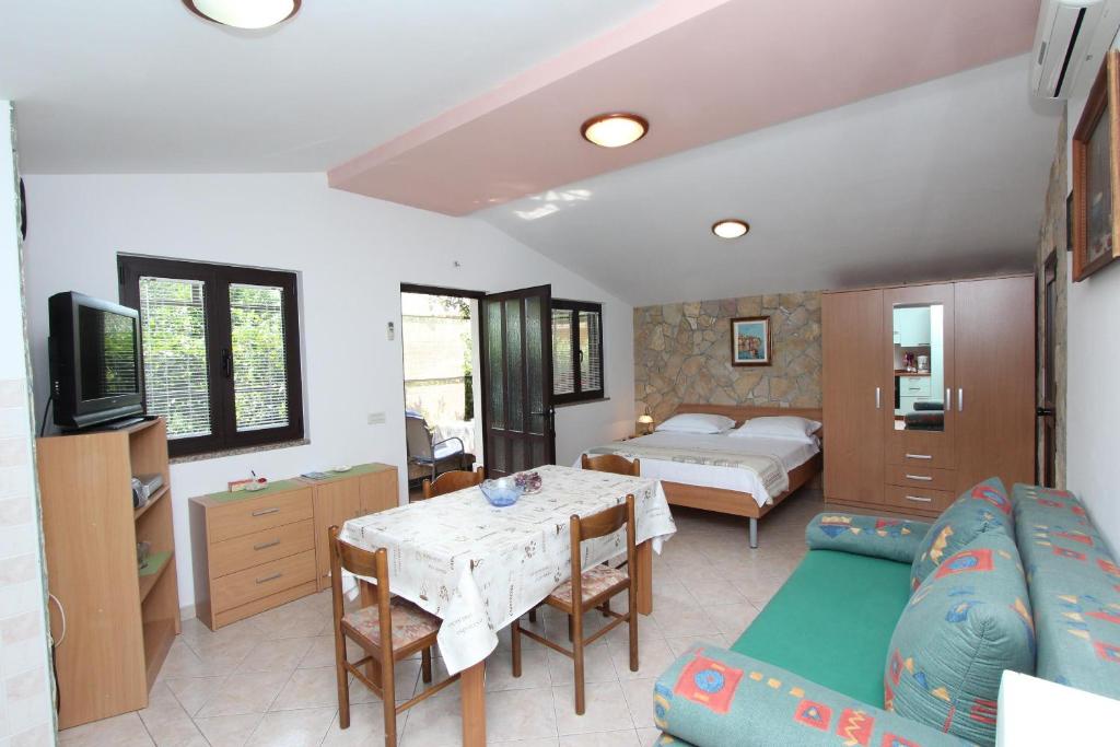 salon z kanapą, stołem i łóżkiem w obiekcie Apartments Marlina w Rovinj