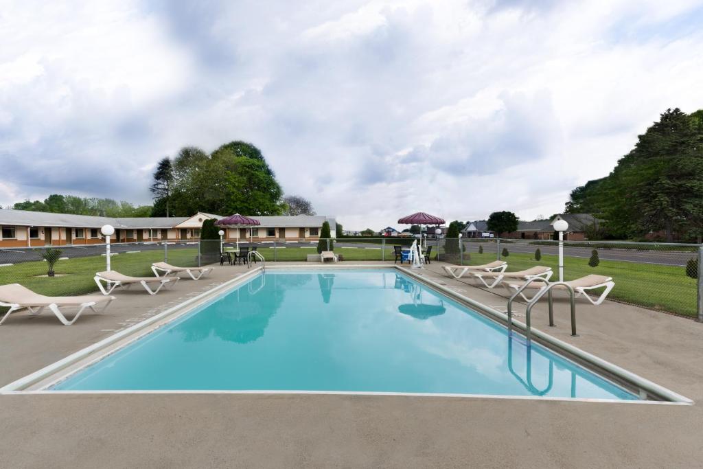 a swimming pool with lounge chairs and a resort at Knights Inn Palmyra in Palmyra