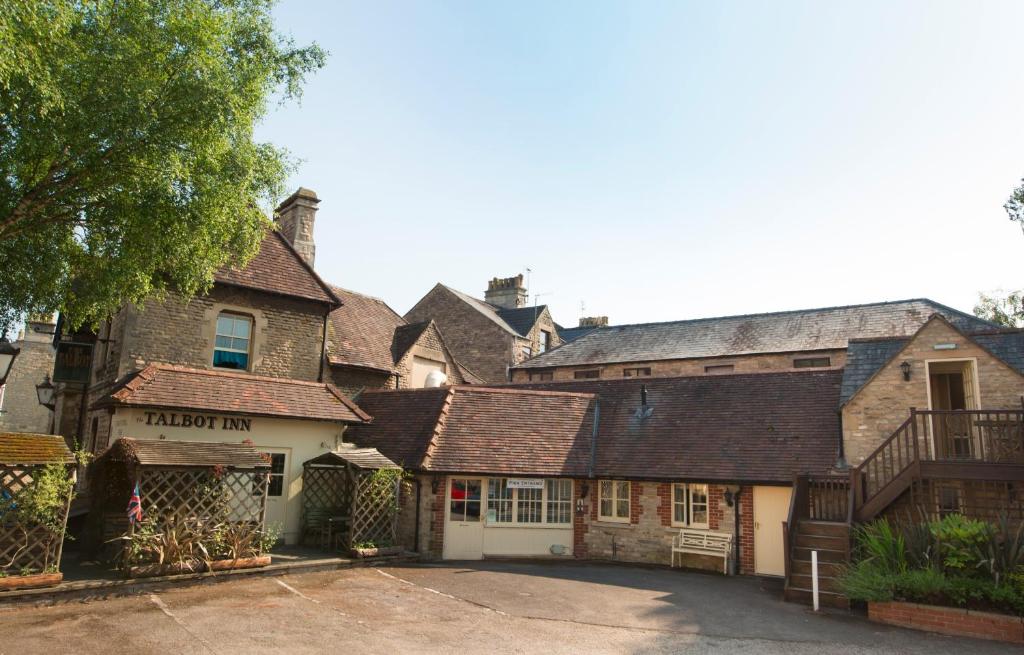 um grupo de edifícios antigos com estacionamento em The Talbot Inn em Cirencester