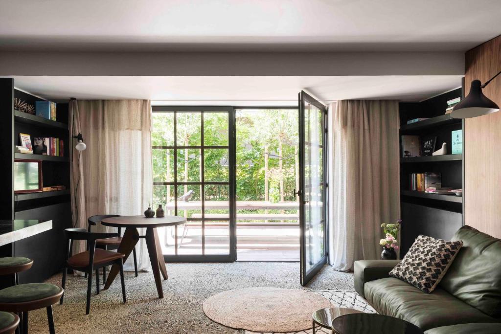 a living room with a couch and a table at Loft Living Garden Suite in Nieuwpoort